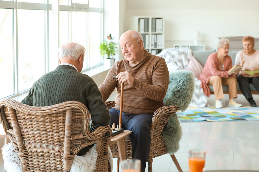 Senior men playing chess in nursing home